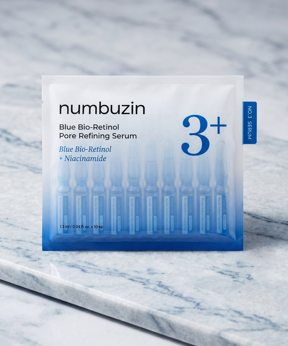 Macro view of a single drop of the Numbuzin Blue Bio-Retinol serum on a clean surface, showcasing its glossy, high-absorption consistency and unique natural blue tint