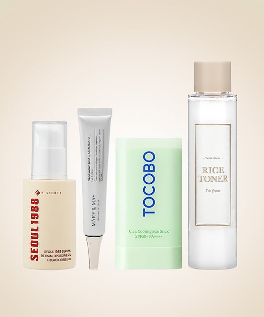 Collection of skincare products including a bottle, tube, and stick on a beige background