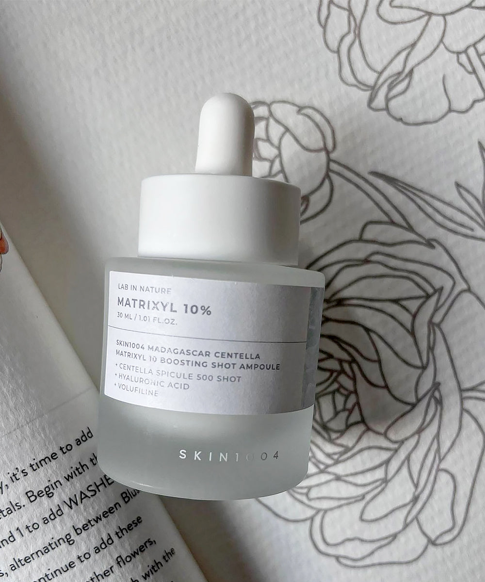 Skintox skincare bottle with dropper on a floral-patterned surface