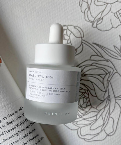 Skintox skincare bottle with dropper on a floral-patterned surface