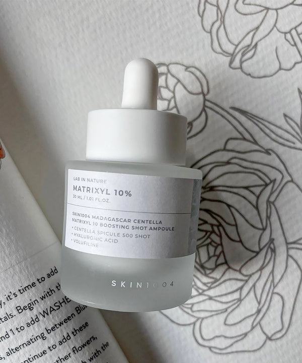 Skintox skincare bottle with dropper on a floral-patterned surface