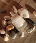 Skincare bottle with text on a wooden surface with stones