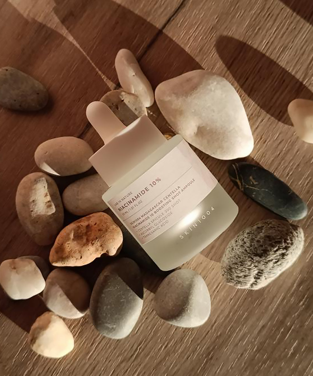 Skincare bottle with text on a wooden surface with stones