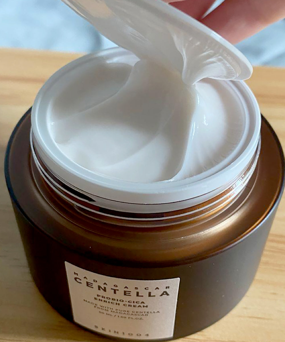 Jar of cream with a visible brand label on a wooden surface