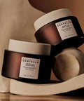 Two skincare jars with labels on a wooden surface