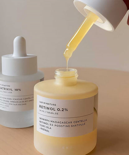 Skincare product with dropper being used on a beige background