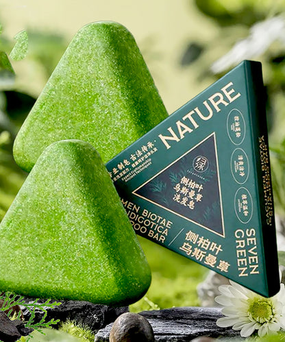 Two green soap bars with a box labeled 'Seven Green' on a natural background.