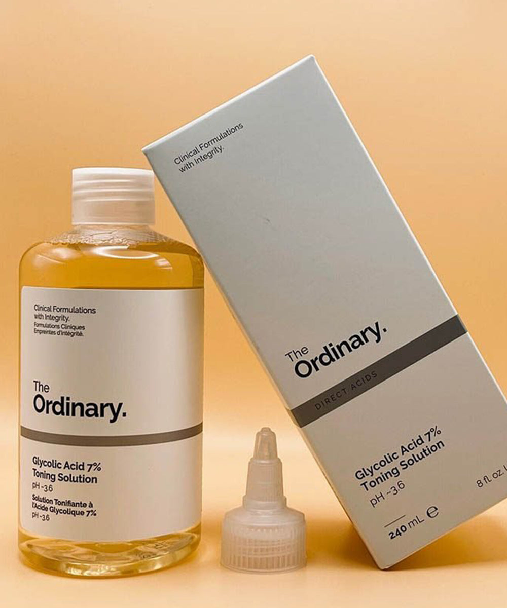 The Ordinary glycolic acid toning solution bottle, box, and spray on a beige background