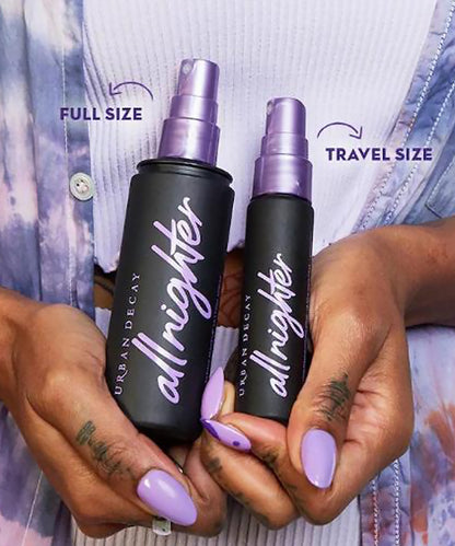 Two 'allrighter' spray bottles, one full size and one travel size, held by hands with purple nail polish.