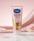 Vaseline Gluta-Hya lotion tube on a pink fabric background with roses.