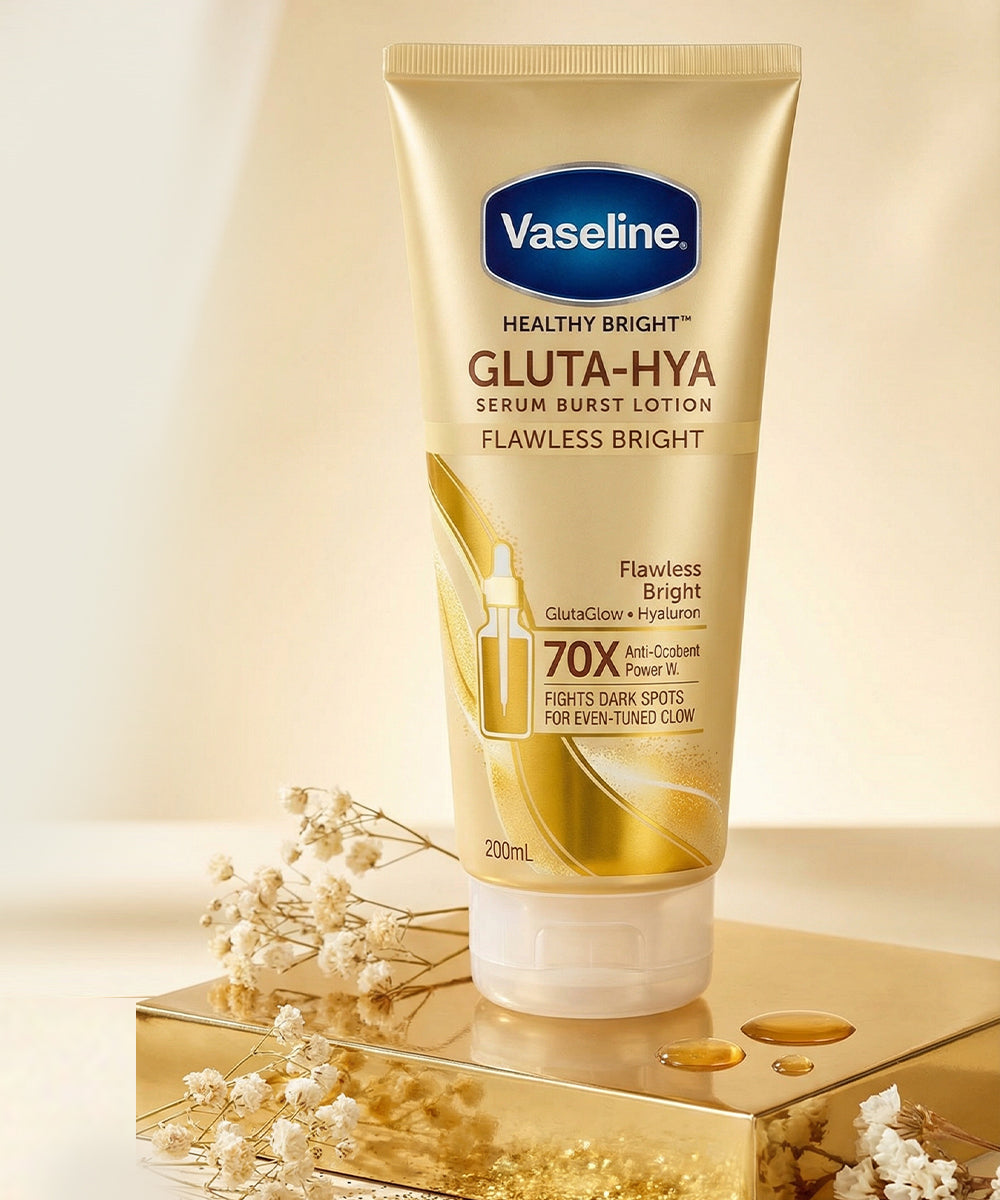 Vaseline Healthy Bright Gluta-Hya lotion tube on a reflective surface with flowers.