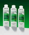 Three bottles of Vichy Dercos Anti-dandruff Shampoo on a green background