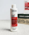 Vichy Dercos Stimulating Shampoo bottle on a wooden surface with a blurred background